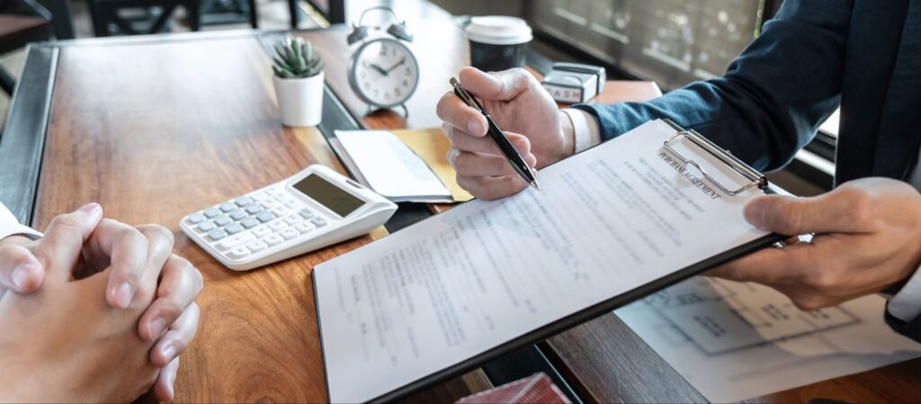 Two people sitting at a table with a clipboard, discussing installment loan options.