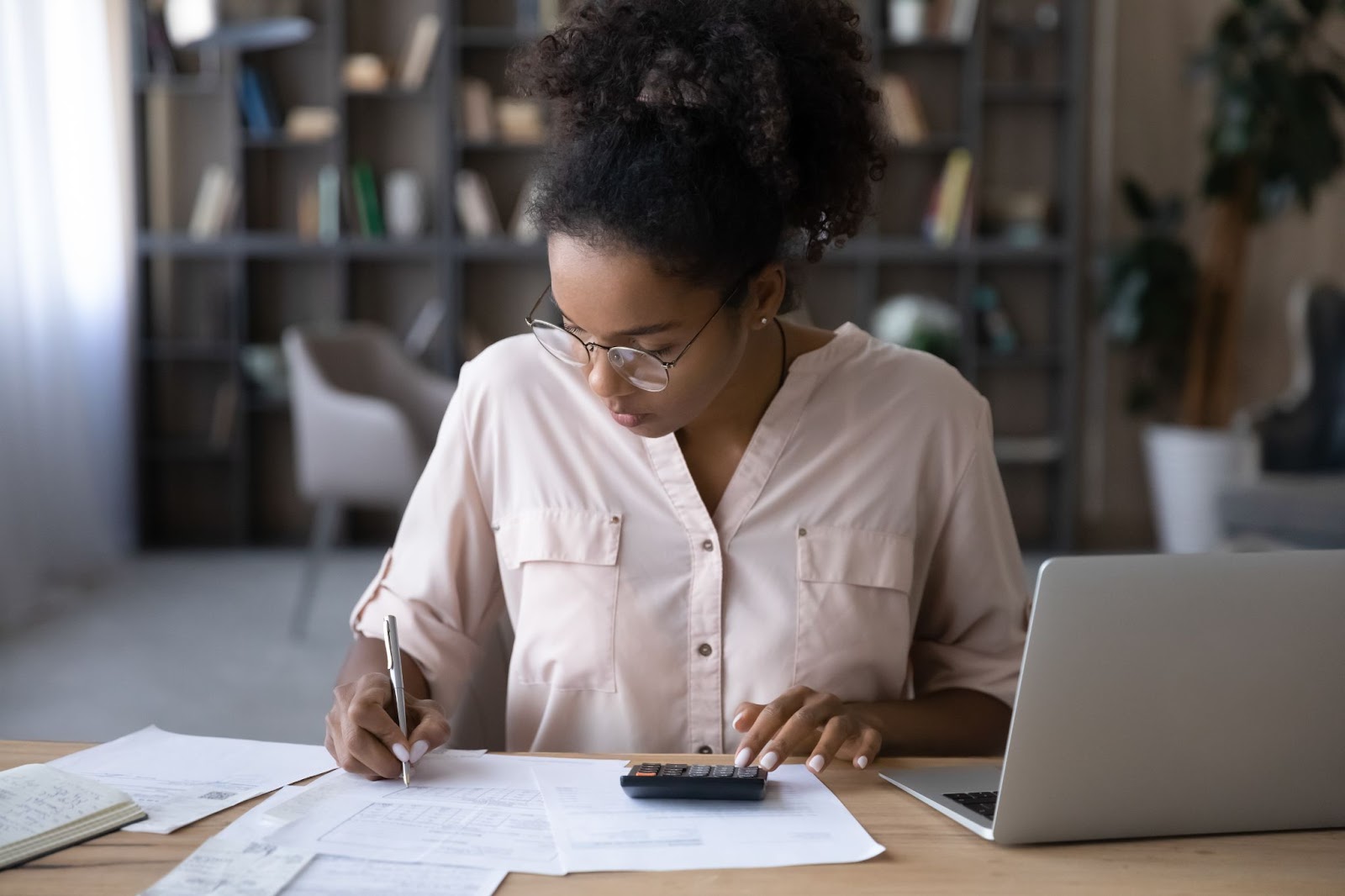 A woman at a desk, focused on her laptop and working professionally