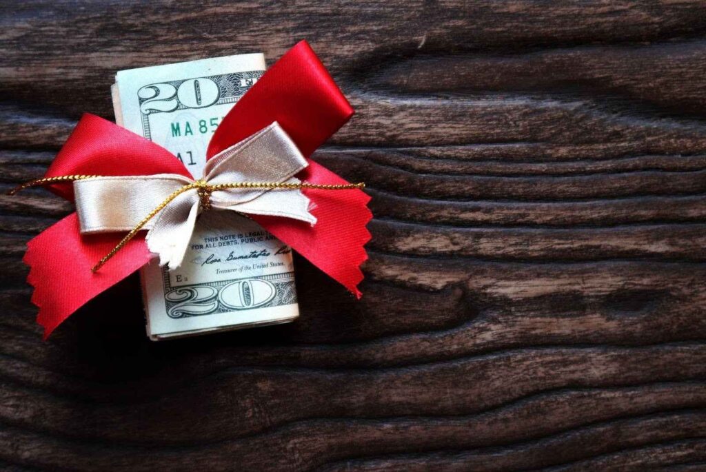 A money bundle tied with a red ribbon and bow, representing prosperity