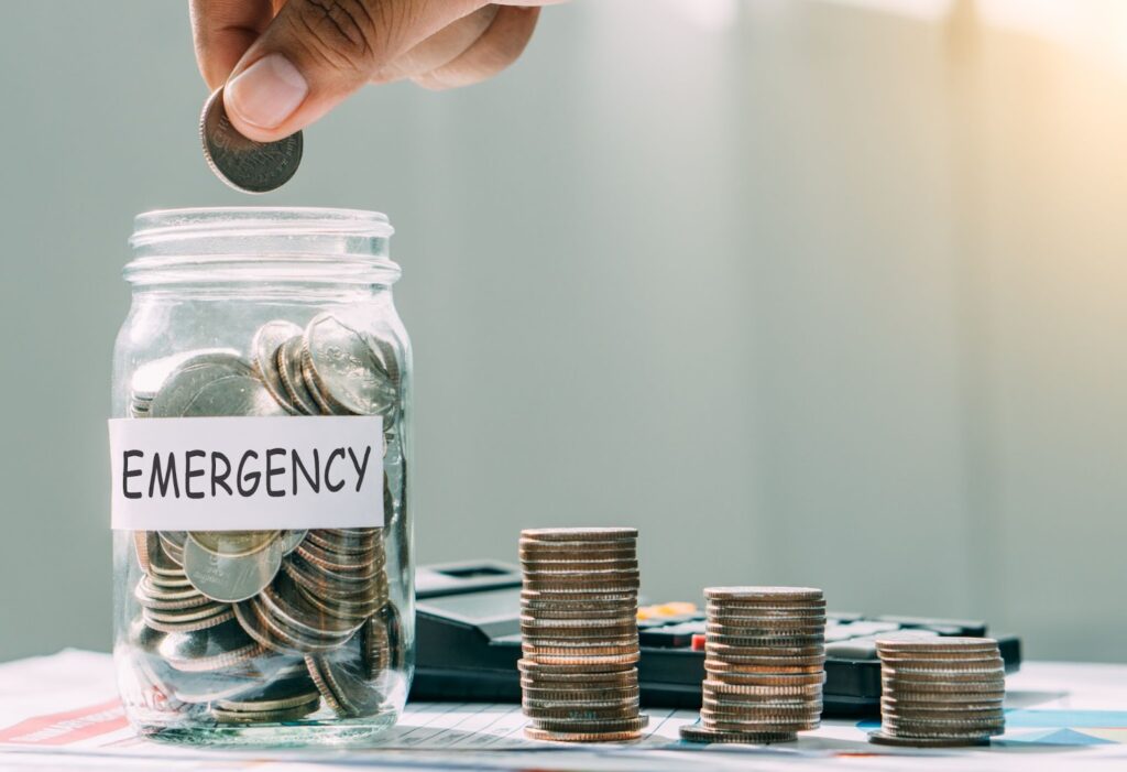 A savings jar filled with coins and cash, symbolizing emergency funds for financial crises and avoiding payday loans.