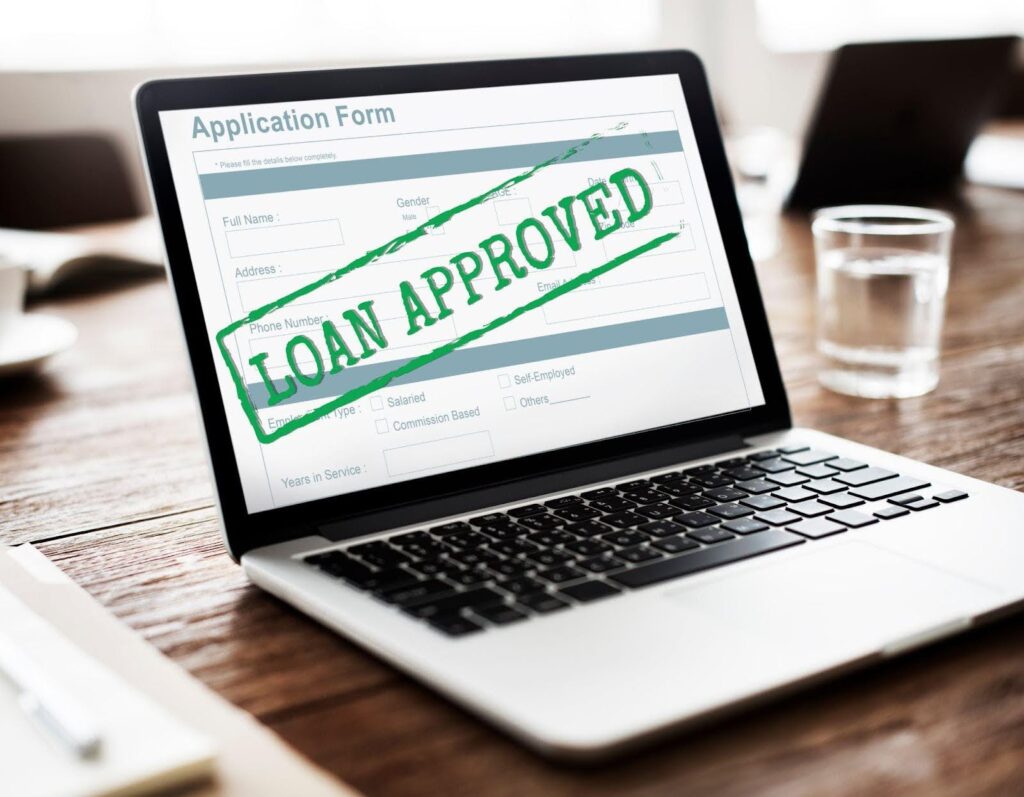 A close-up of a laptop showing a message confirming loan approval