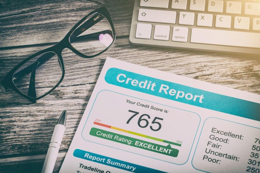Credit report on a desk with glasses and a pen indicating a financial review