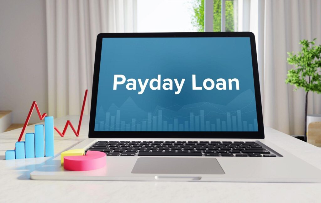 A laptop screen displays Payday Loan in white text
