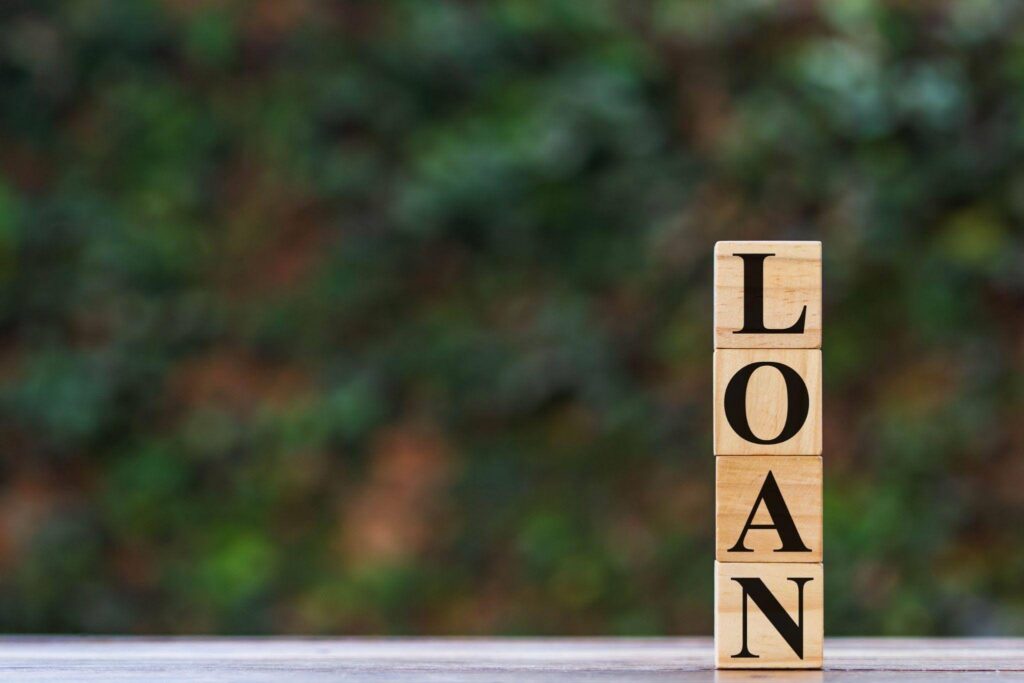A set of wooden blocks displaying the phrase loan word illustrating a concept in language studies